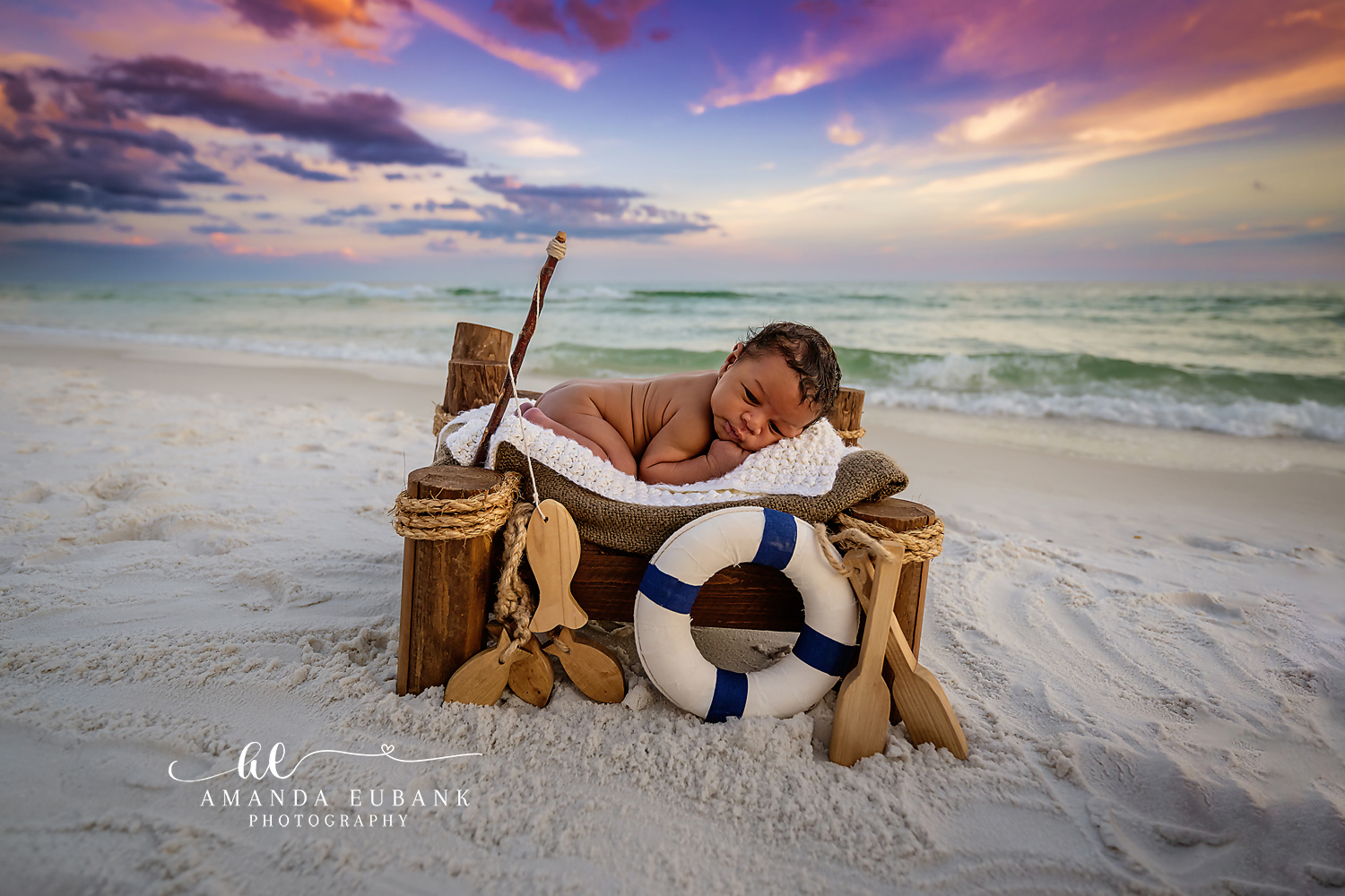Destin Newborn Photographer | Nautical Beach Newborn Session Destin newborn photographer captures sleeping baby in a nautical setup with anchor and rope on the beach in Destin, Florida.
